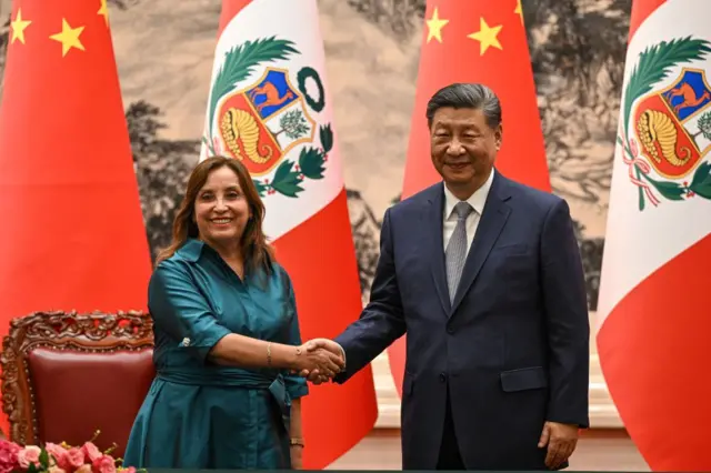 La presidenta de Perú, Dina Boluarte, y el presidente de China, Xi Jinping, posan dándose la mano en una reciente reunión en Beijing. 