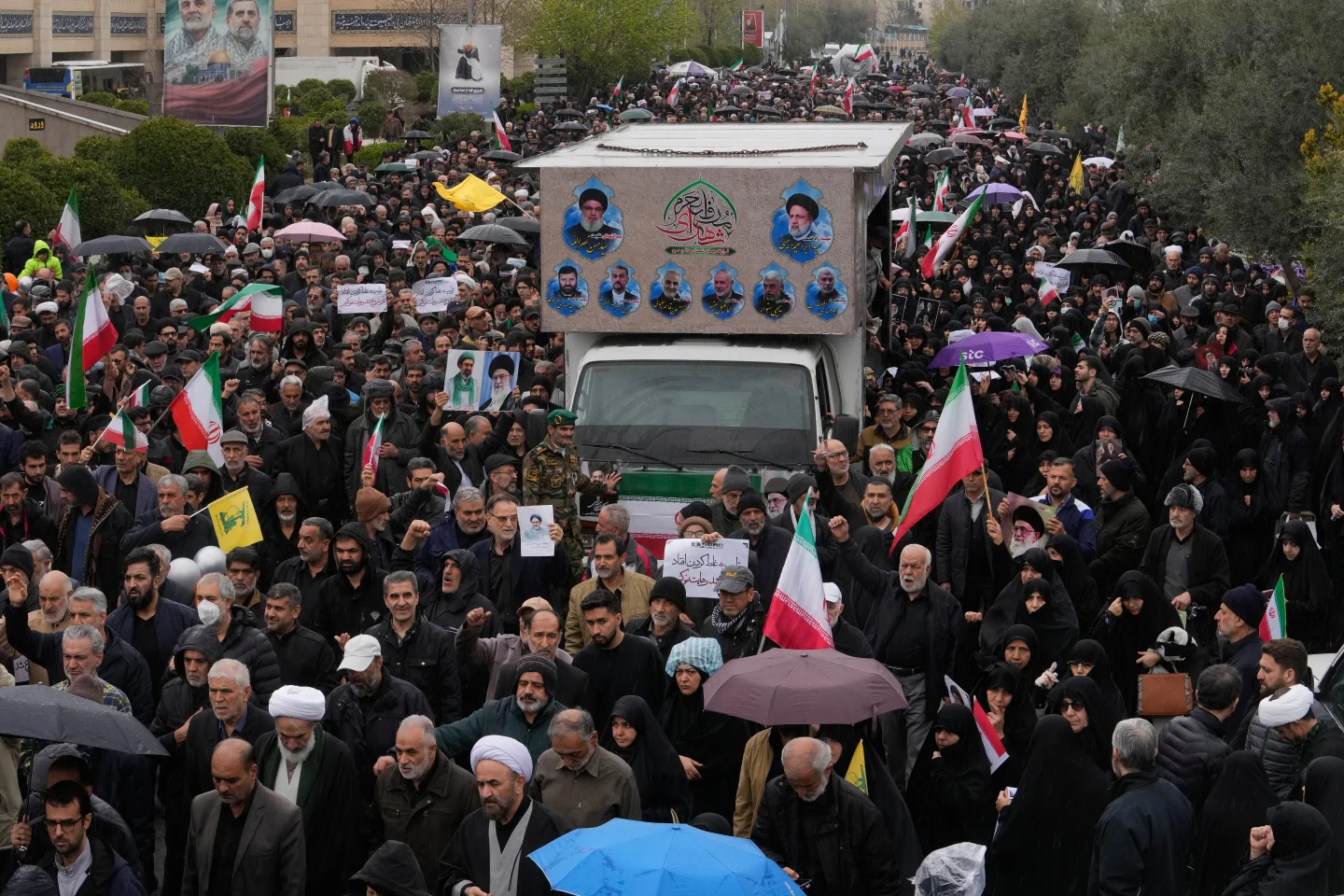 Ciudadanos iraníes siguen un camión que transporta los ataúdes del Ministro de Inteligencia de Irán el viernes 20 de marzo.