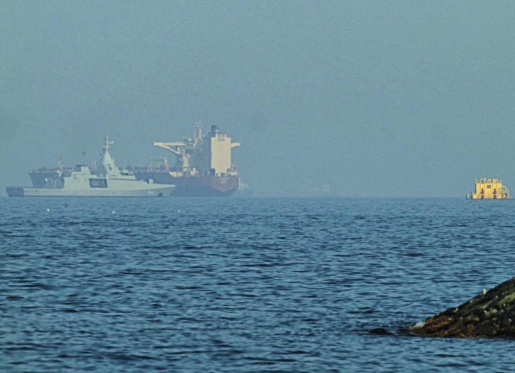 Una patrullera emiratí (izquierda) navega cerca de un petrolero anclado en el Golfo de Omán, cerca del Estrecho de Ormuz, visto desde una carretera costera cerca de Khor Fakkan, Emiratos Árabes Unidos, el 1 de mayo de 2026. (Foto AP/Fatima Shbair)