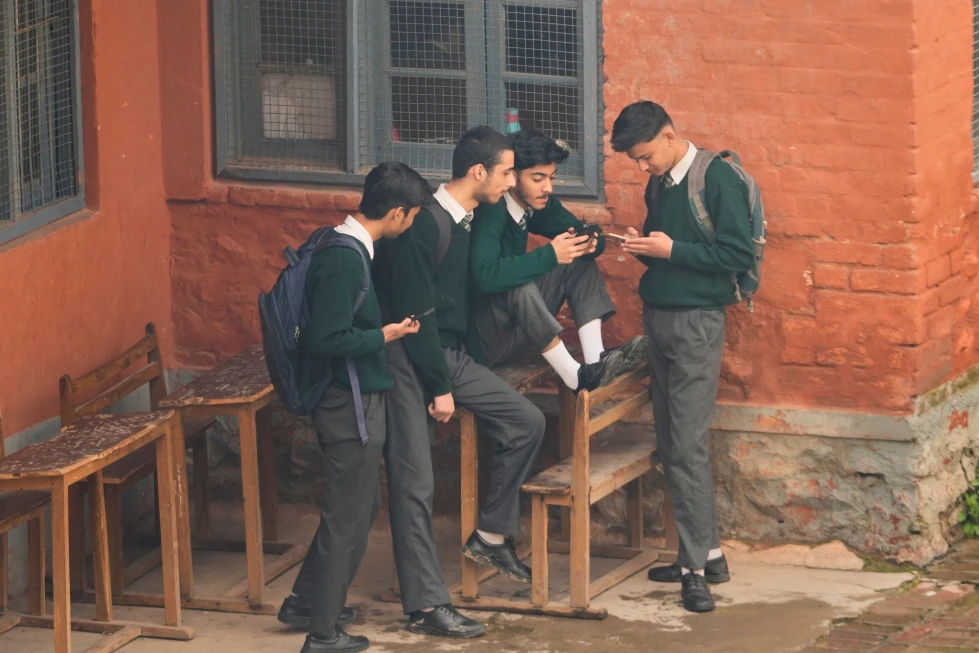 Los estudiantes revisan sus teléfonos celulares en un complejo escolar en Srinagar, Cachemira controlada por la India.