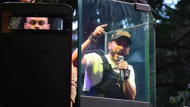 Abelardo de la Espriella, en un acto de campaña usando chaleco antibalas y protegido por escudos blindados.