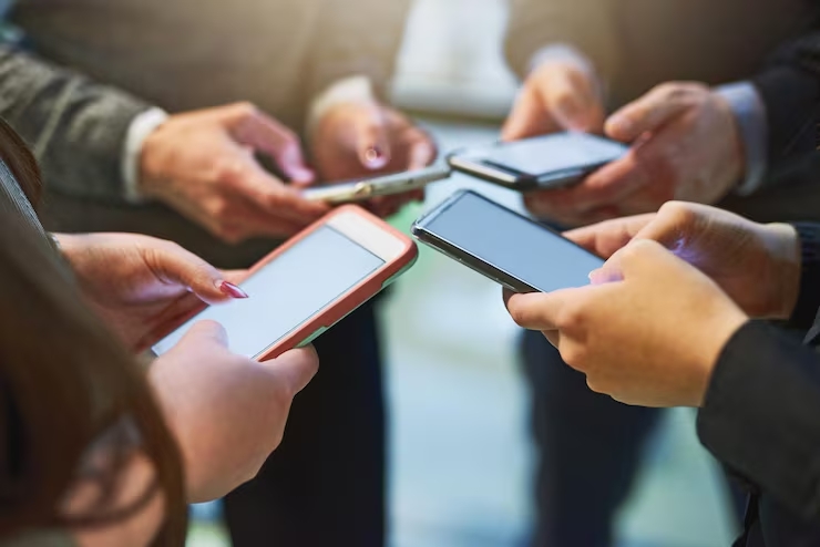 La gente sostiene sus teléfonos celulares