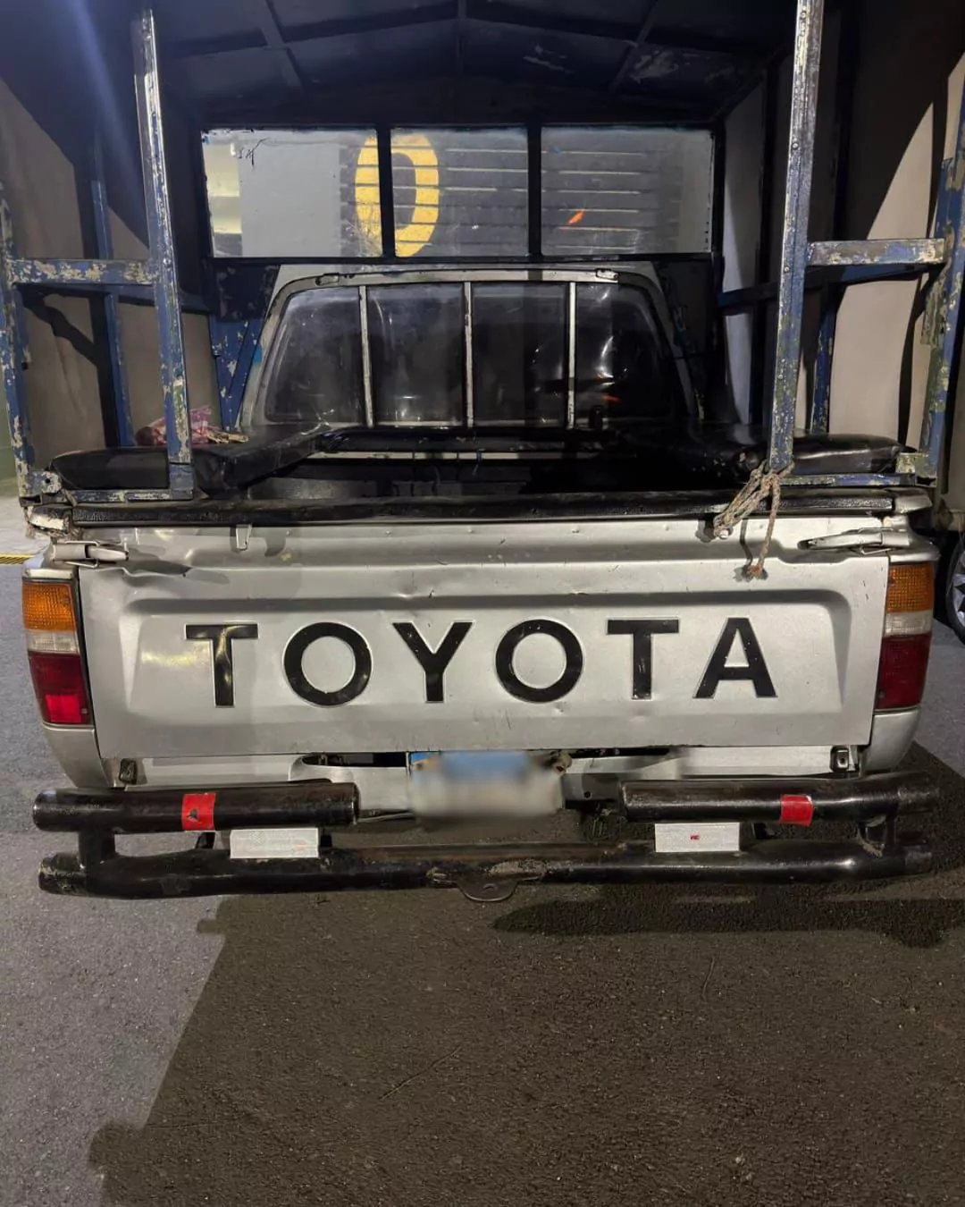 Parte trasera de una camioneta Toyota con estructura metálica estacionada por la noche