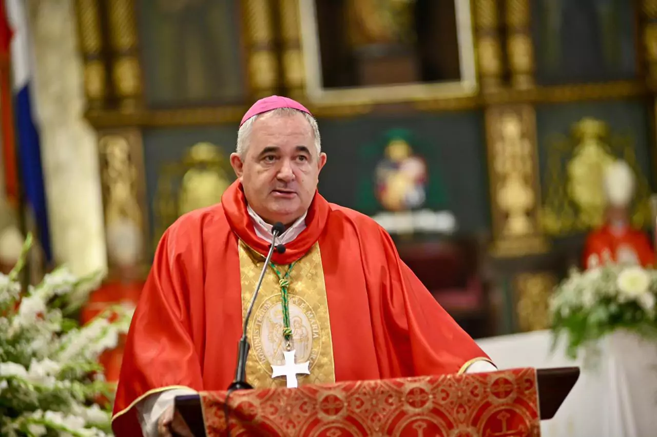 Obispo católico con vestimentas rojas durante una ceremonia religiosa en una iglesia