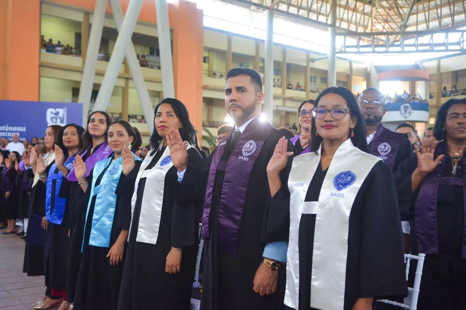 Egresados de la Región Norte de la UASD levantan la mano durante la investidura en Puerto Plata