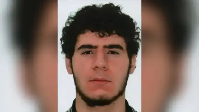 Una fotografía difundida por la policía de Berlín del presunto autor del accidente. El hombre tiene cabello negro, rulos y barba.