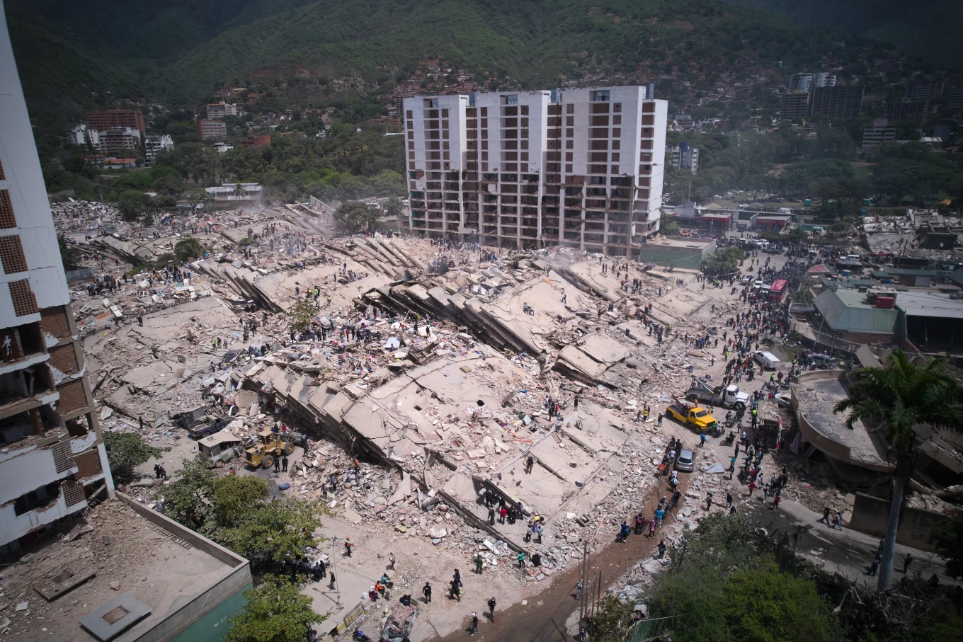 Residentes y equipos de rescate buscan entre los escombros dos días después de que un terremoto sacudiera La Guaira, Venezuela, el viernes 26 de junio de 2026. (Foto AP/Juan Pablo Arraez)