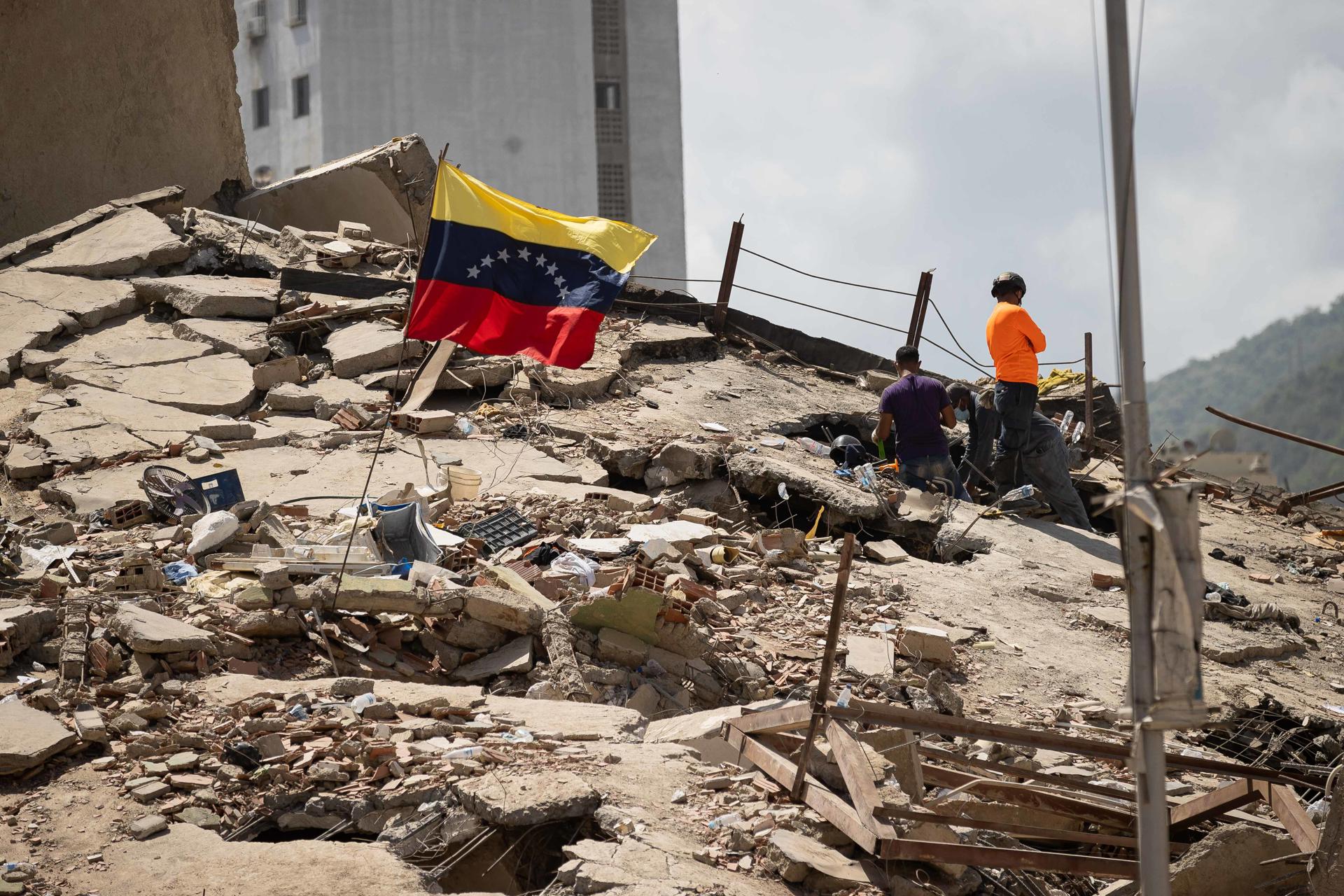 Voluntarios realizan este lunes labores de búsqueda entre los escombros de un edificio, en La Guaira (Venezuela). Han pasado cinco días desde el doble terremoto de magnitud 7,2 y 7,5 que sacudió el norte de Venezuela y los sobrevivientes sienten que no les queda nada para vivir en el estado costero de La Guaira, el más afectado por el desastre. EFE/Ronald Peña R.