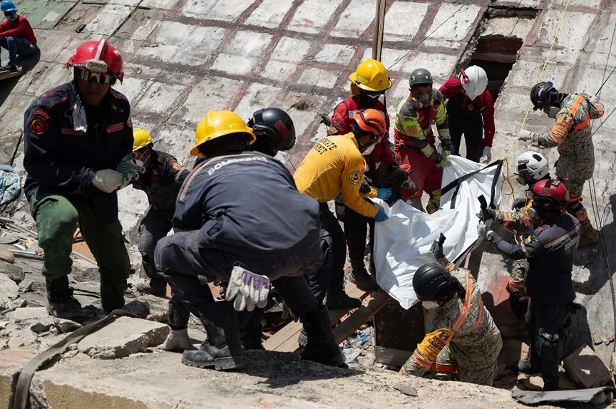Fotografía de los rescatistas recuperando un cuerpo entre los escombros de un edificio afectado por los terremotos, este miércoles, en La Guaira (Venezuela).