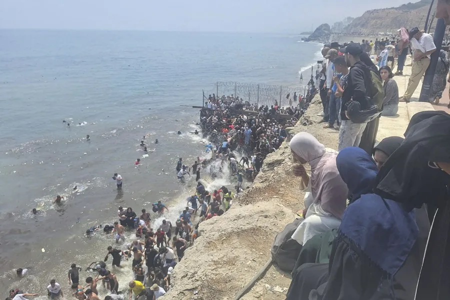 Miles de jóvenes marroquíes se dirigieron este jueves a la frontera entre Castillejos (Marruecos) y Ceuta (España) para intentar cruzar la valla que separa ambas ciudades. EFE/Mar Marín