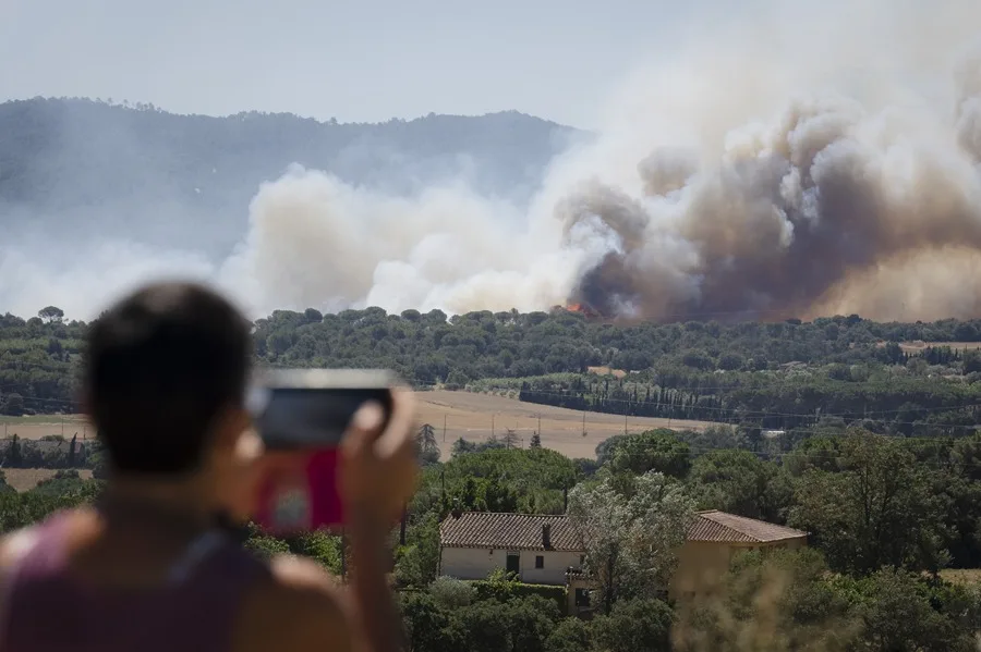 Un hombre observa la columna de humo del incendio forestal declarado en La Bisbal d'Empordà (Girona). EFE
