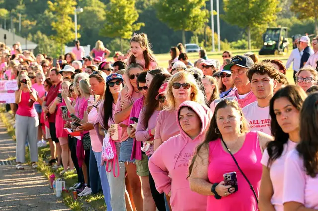 Una fila de mujeres, todas vestidas de rosa, fuera del juicio.
