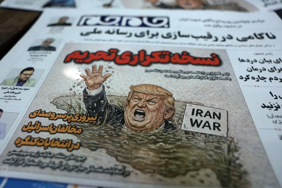 Copias del periódico iraní 'Jame-Jam' con una caricatura del presidente estadounidense Donald Trump y un titular en persa que dice 'Versión duplicada de las sanciones' informando sobre la nueva amenaza económica contra Irán, junto a un quiosco en Teherán. EFE/EPA/ABEDIN TAHERKENAREH