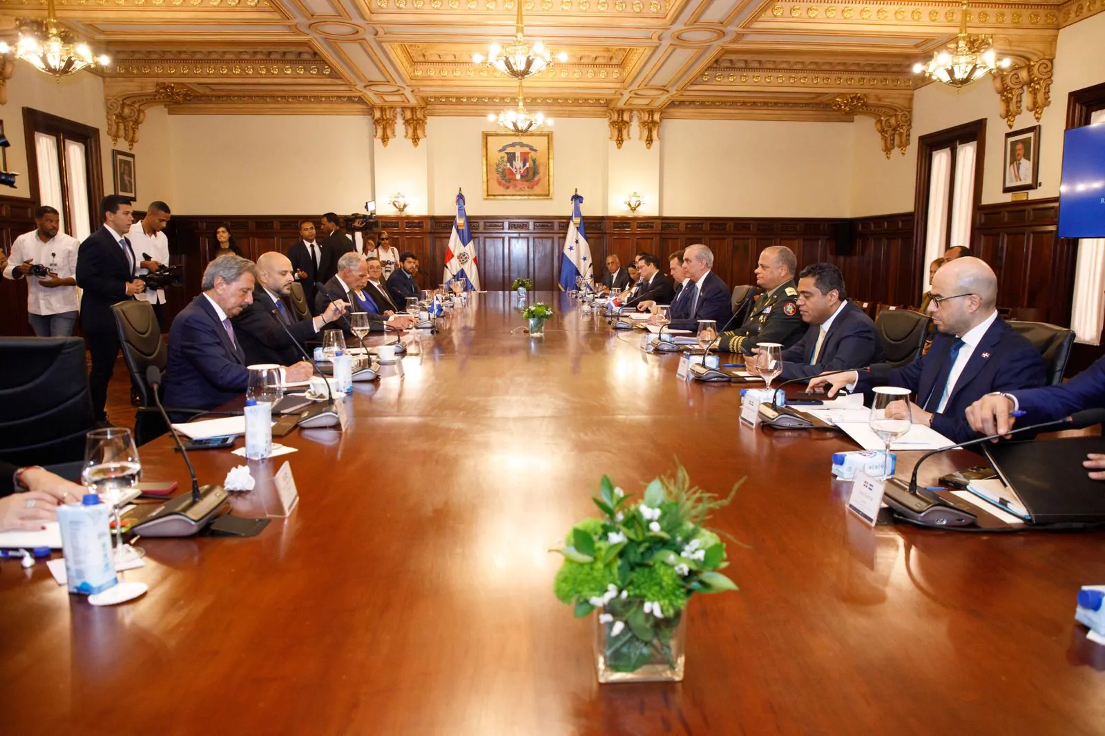 Funcionarios reunidos en mesa de trabajo en salón oficial con banderas de República Dominicana y Honduras
