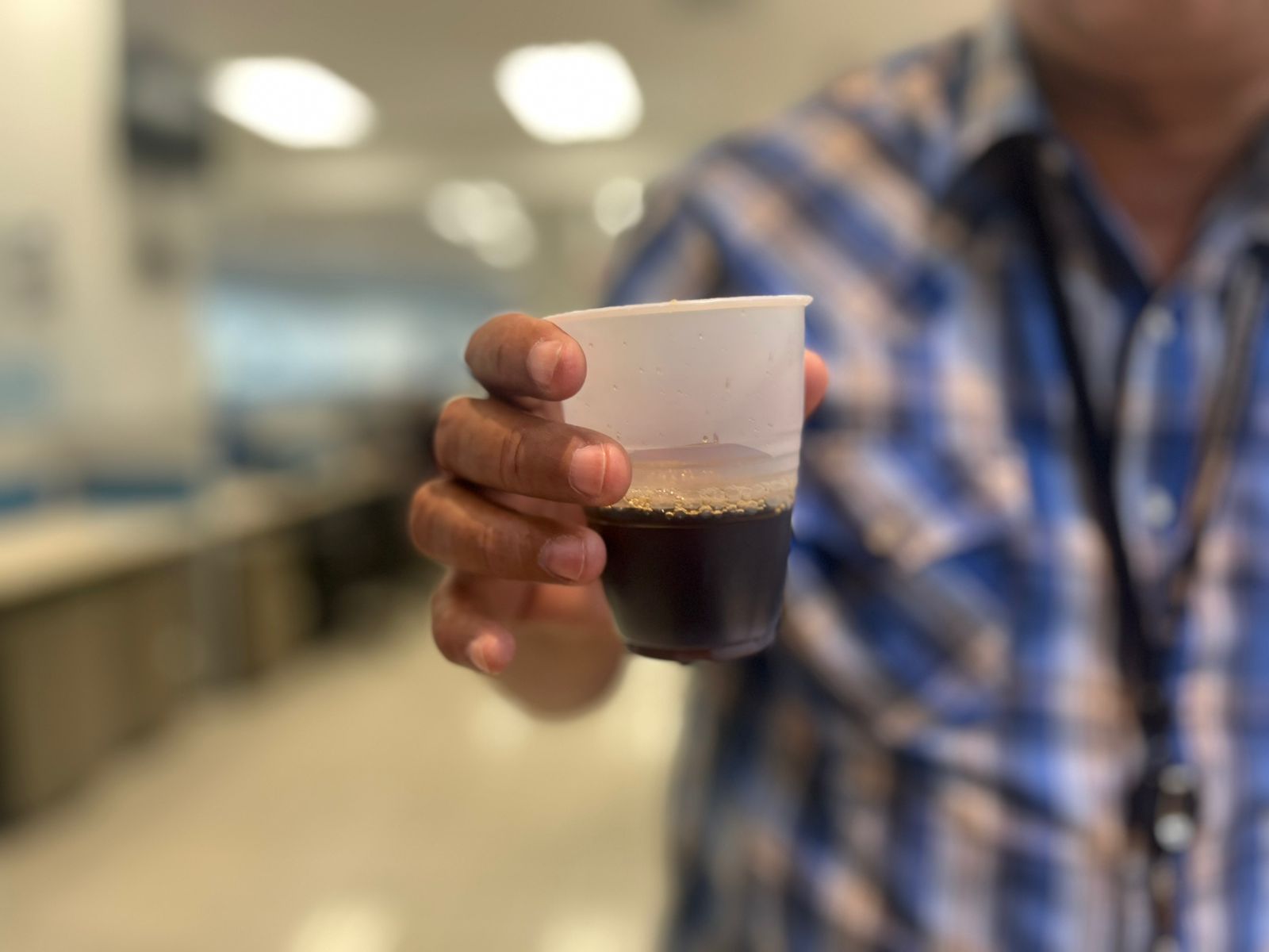 Un hombre sostiene un vaso de café. Foto de referencia
