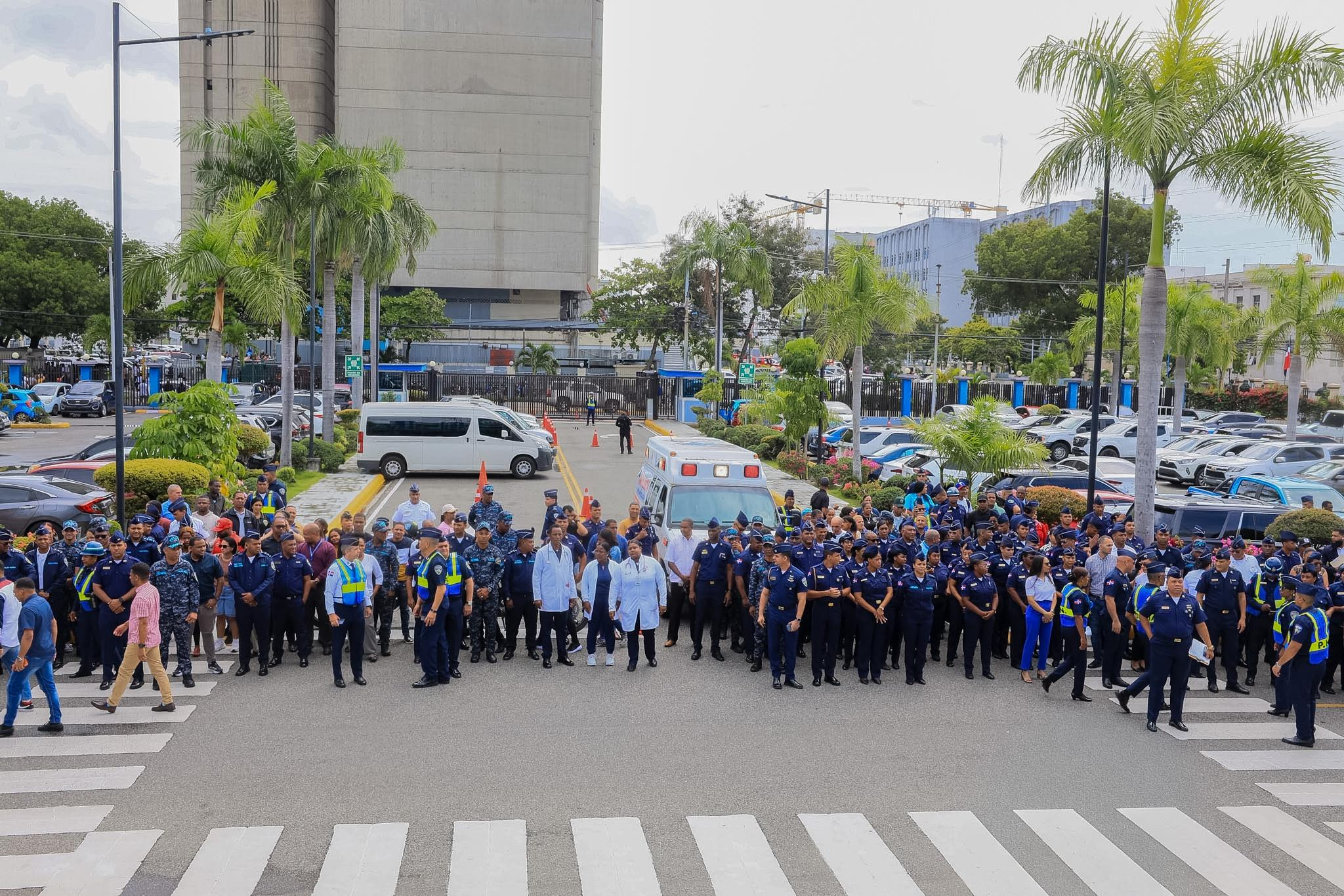 Agentes y personal evacuados frente a la sede de la policía durante un simulacro de terremoto en Santo Domingo