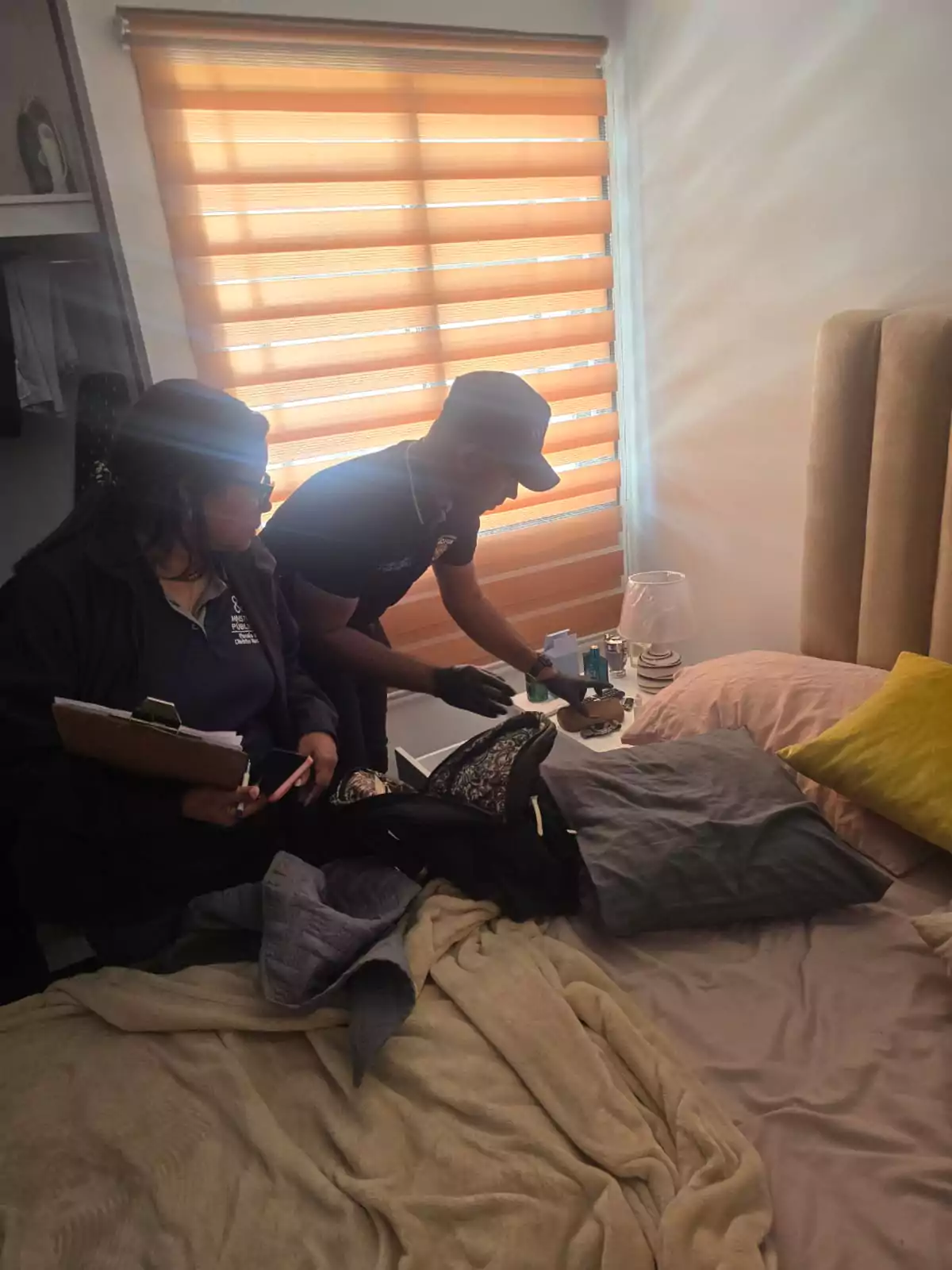 Agentes y personal del Ministerio Público inspeccionan una habitación durante un allanamiento