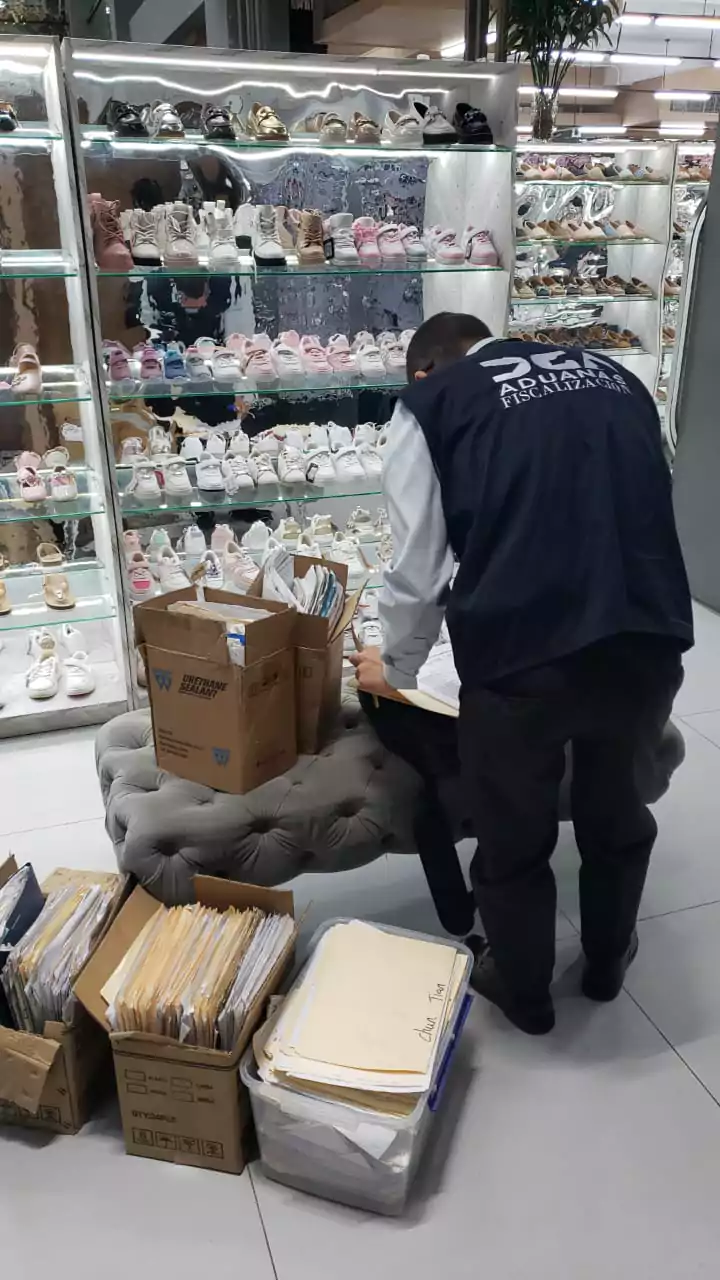 Inspector de Aduanas revisa documentos en una zapatería durante la inspección de impuestos no declarados en la República Dominicana.