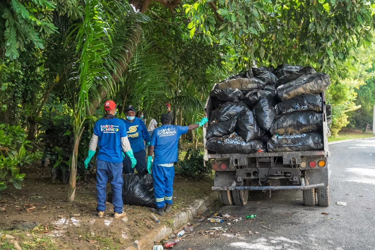 Brigadistas cargan bolsas de basura en un camión durante una jornada de limpieza en Santo Domingo por el Día Internacional de las Playas