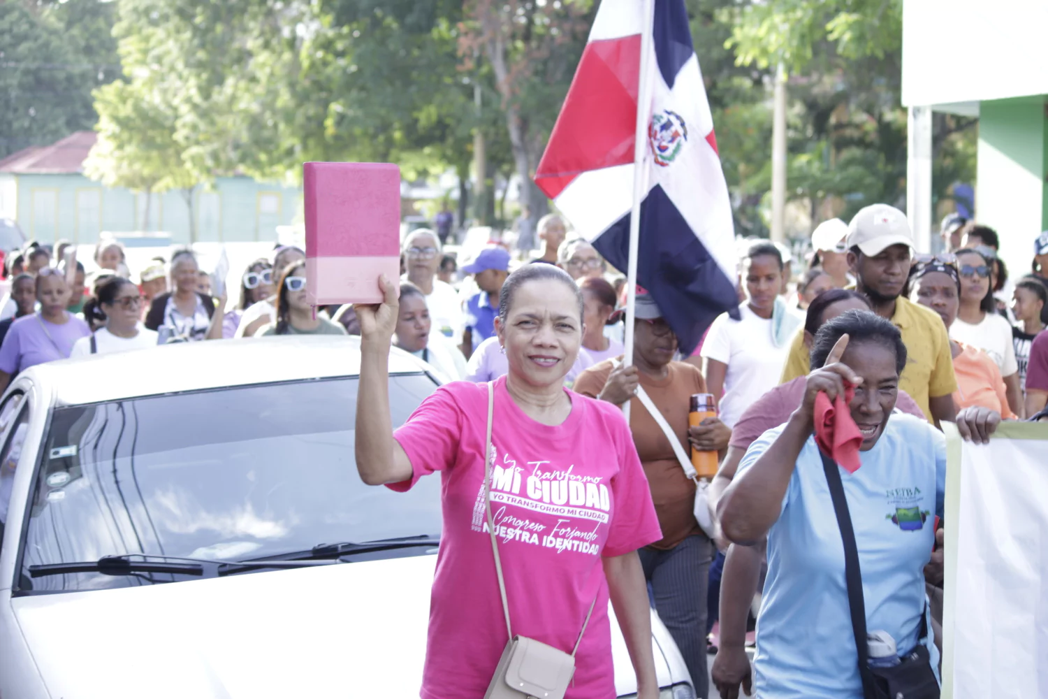 Mujer levanta una Biblia durante marcha evangélica en Neiba por el Día Nacional de la Biblia