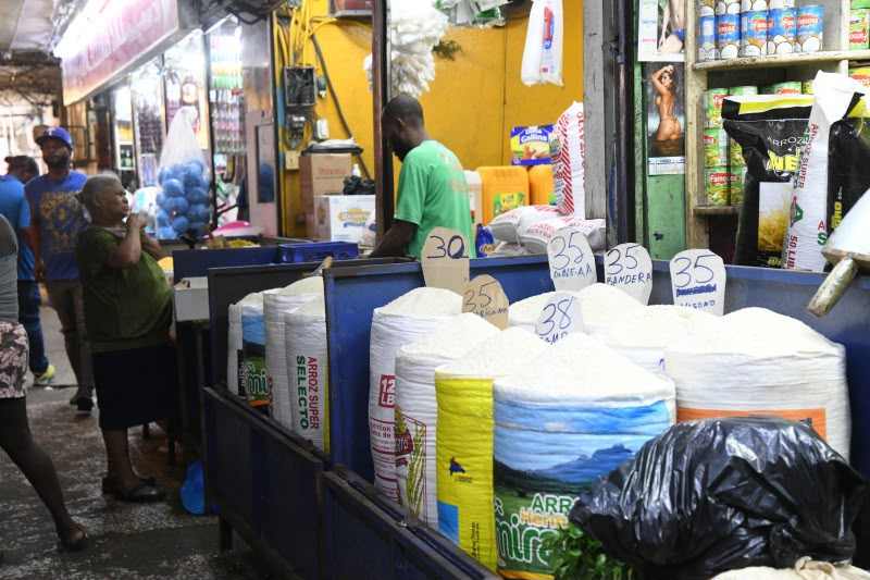Puesto en el mercado con bolsas de arroz y carteles de precios en una tienda en la República Dominicana