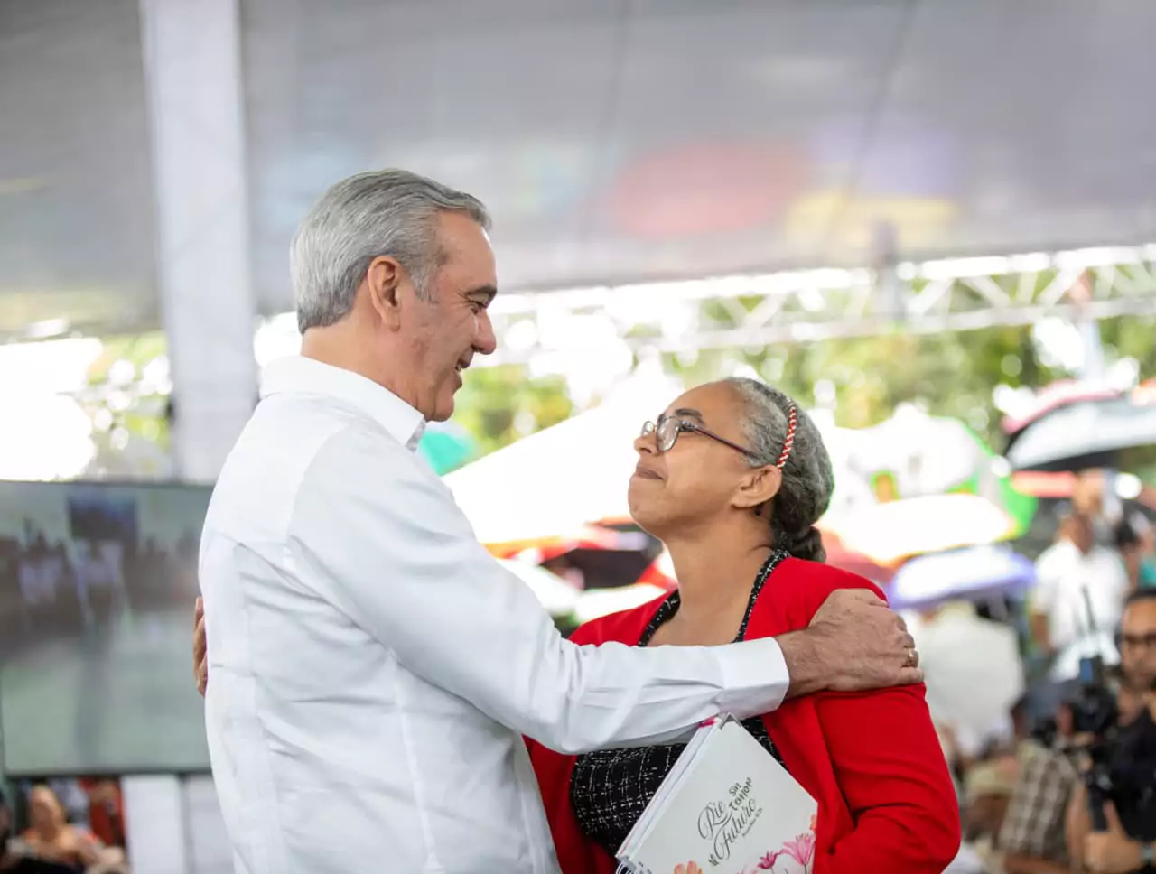 Abinader abraza a una mujer durante actividad de entrega de títulos y viviendas en República Dominicana