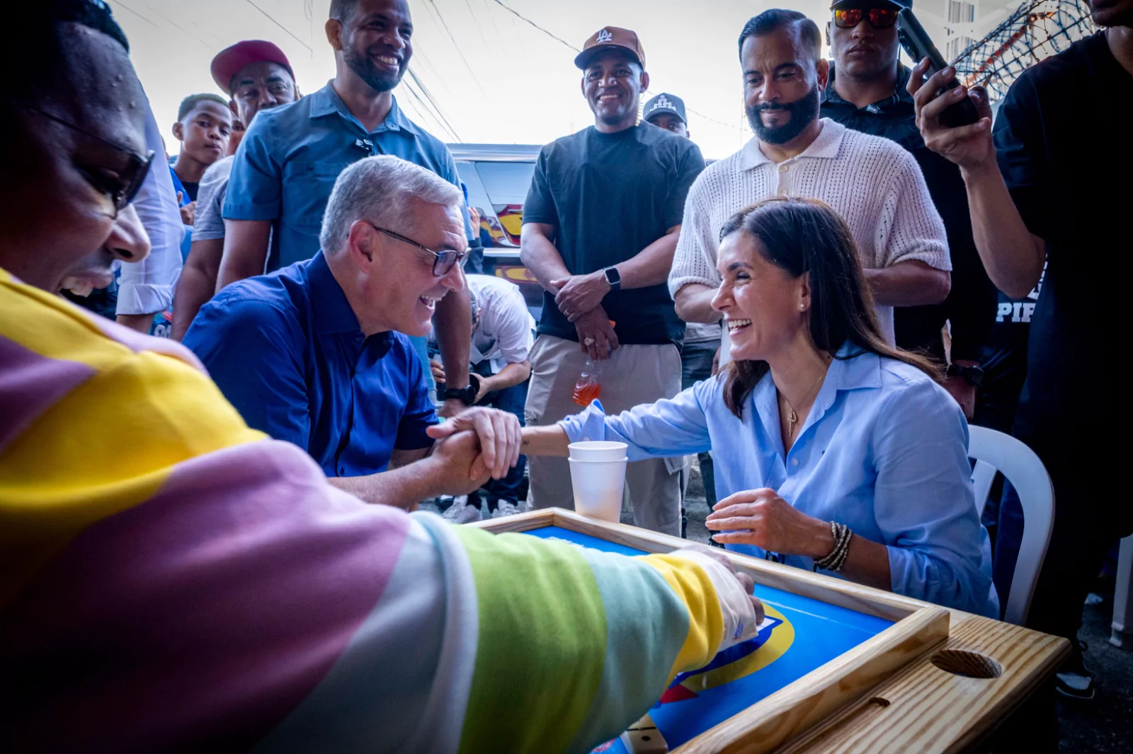 Gonzalo Castillo y Leah Campos se saludan durante una actividad comunitaria en Baní por el 250 aniversario de Estados Unidos.