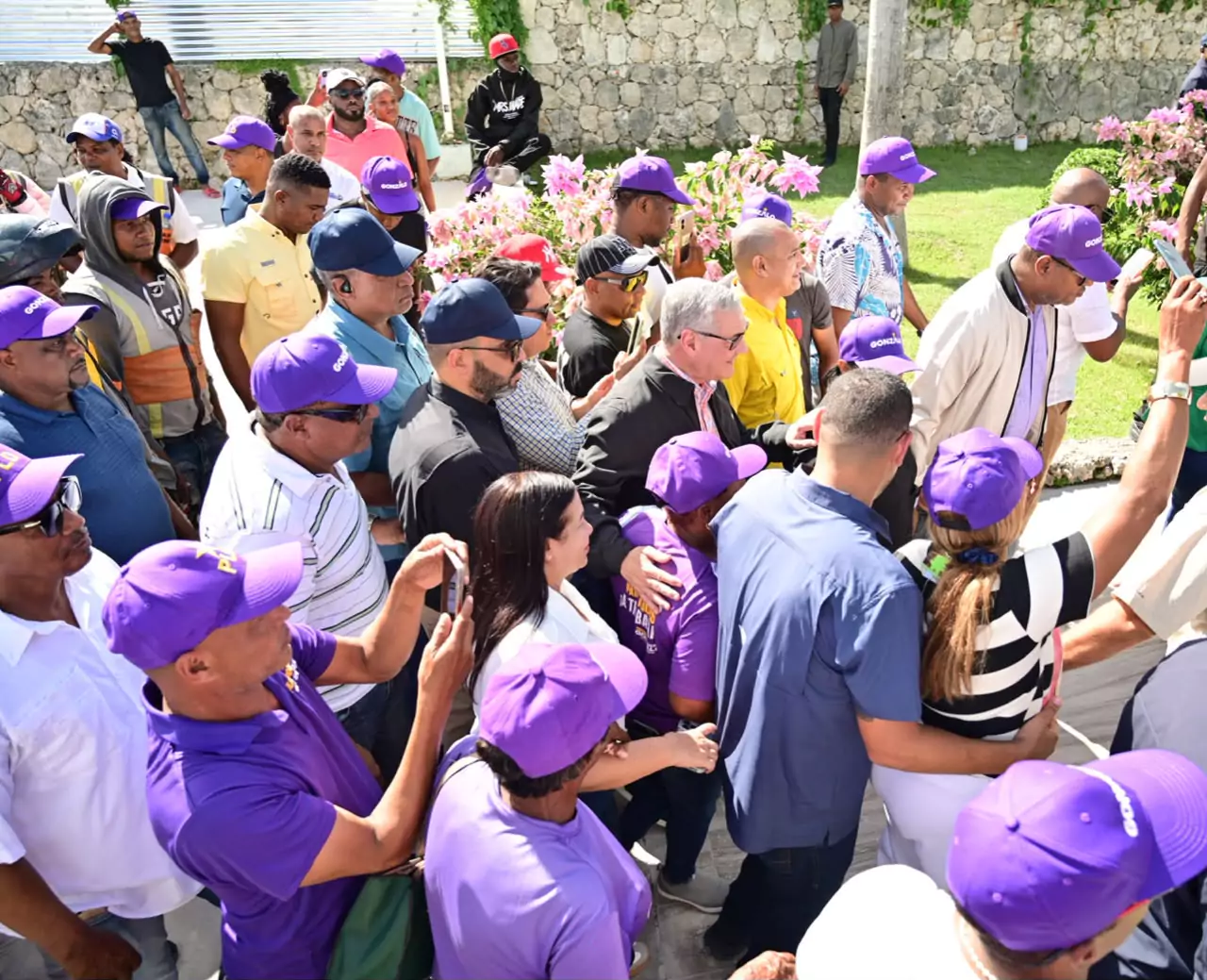 Multitud se reunió en actividad pública con personas con gorras moradas en República Dominicana