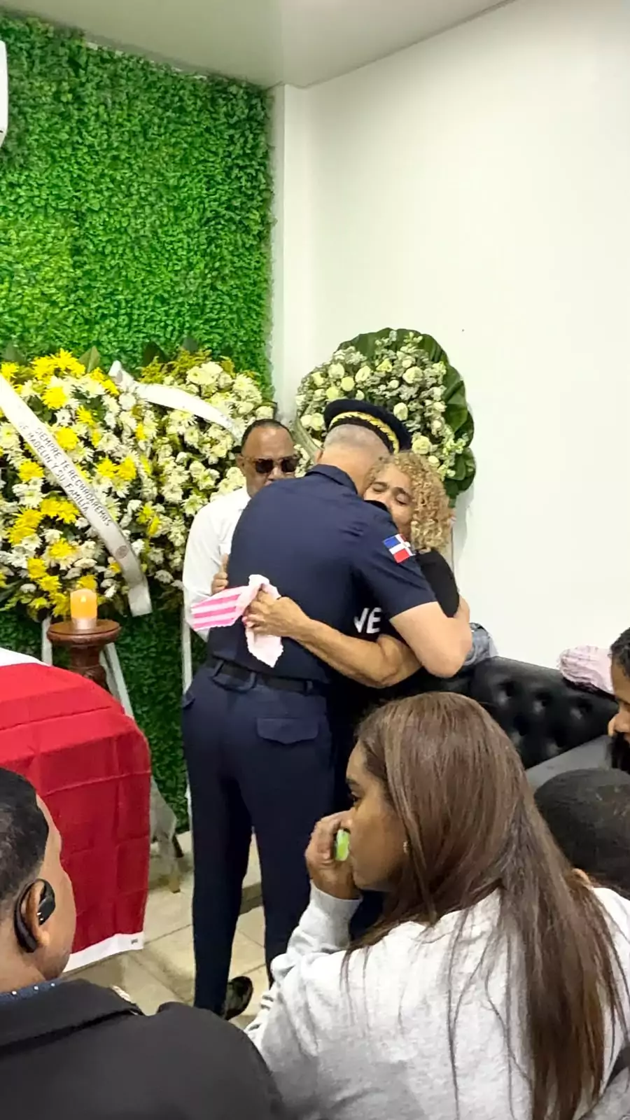 Policía abraza a mujer durante velorio del sargento José Ramón Henríquez Mejía en Santiago
