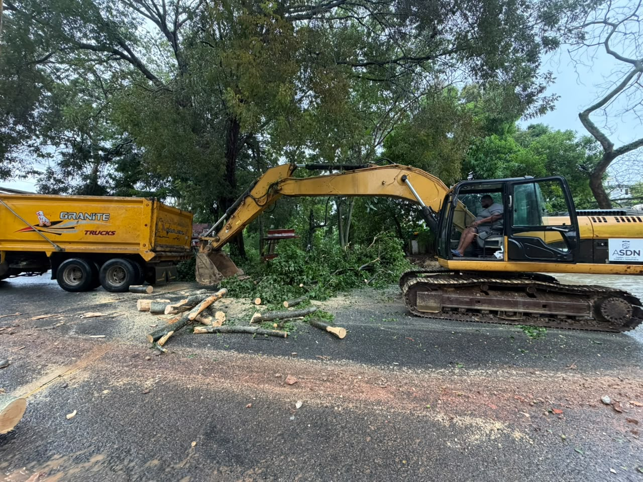 Excavadora y camión de la Alcaldía de Santo Domingo Norte retiran árboles y escombros tras inundación en barranco