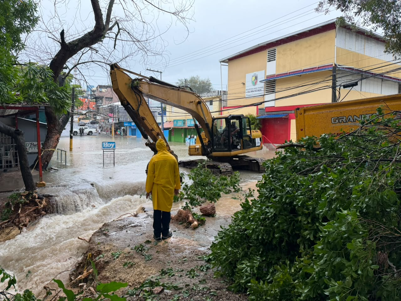 Retroexcavadora y personal bajo la lluvia intervienen en barranco desbordado tras inundación en Santo Domingo Norte