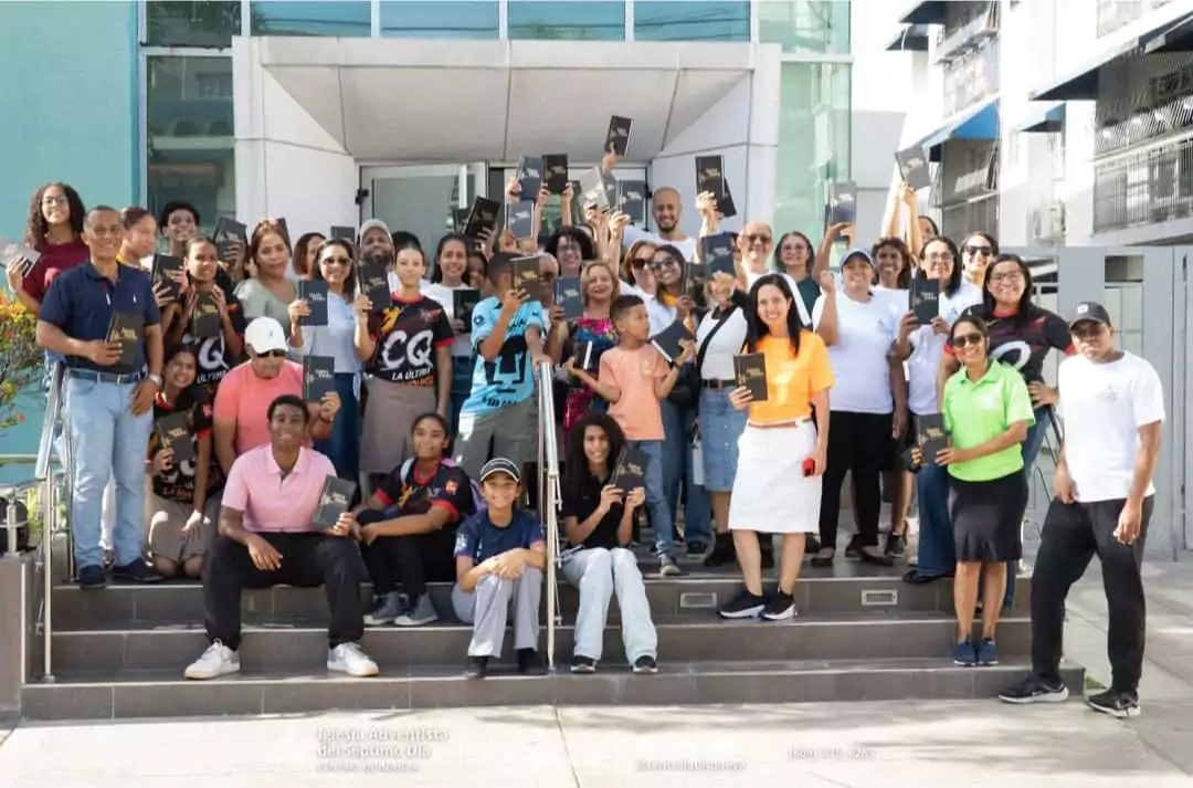 Grupo de personas sostienen Biblias frente a un edificio durante una jornada de la Iglesia Adventista en el Distrito Nacional